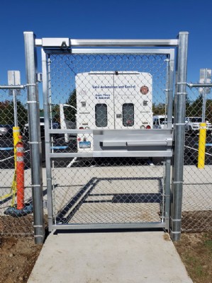 Close up photo of security gate door with Eagle Fence & Guardrail van in the background